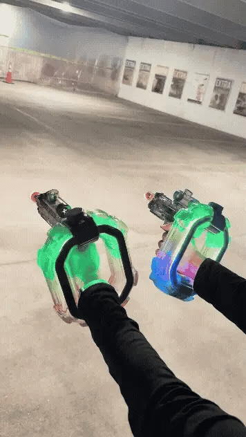 Dual neon water blasters firing in the dark