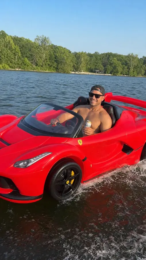 Customer driving the red DriftFloat LaFerrari across a lake with spray